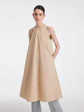 a lady in camel color a-line vest dress with jeans